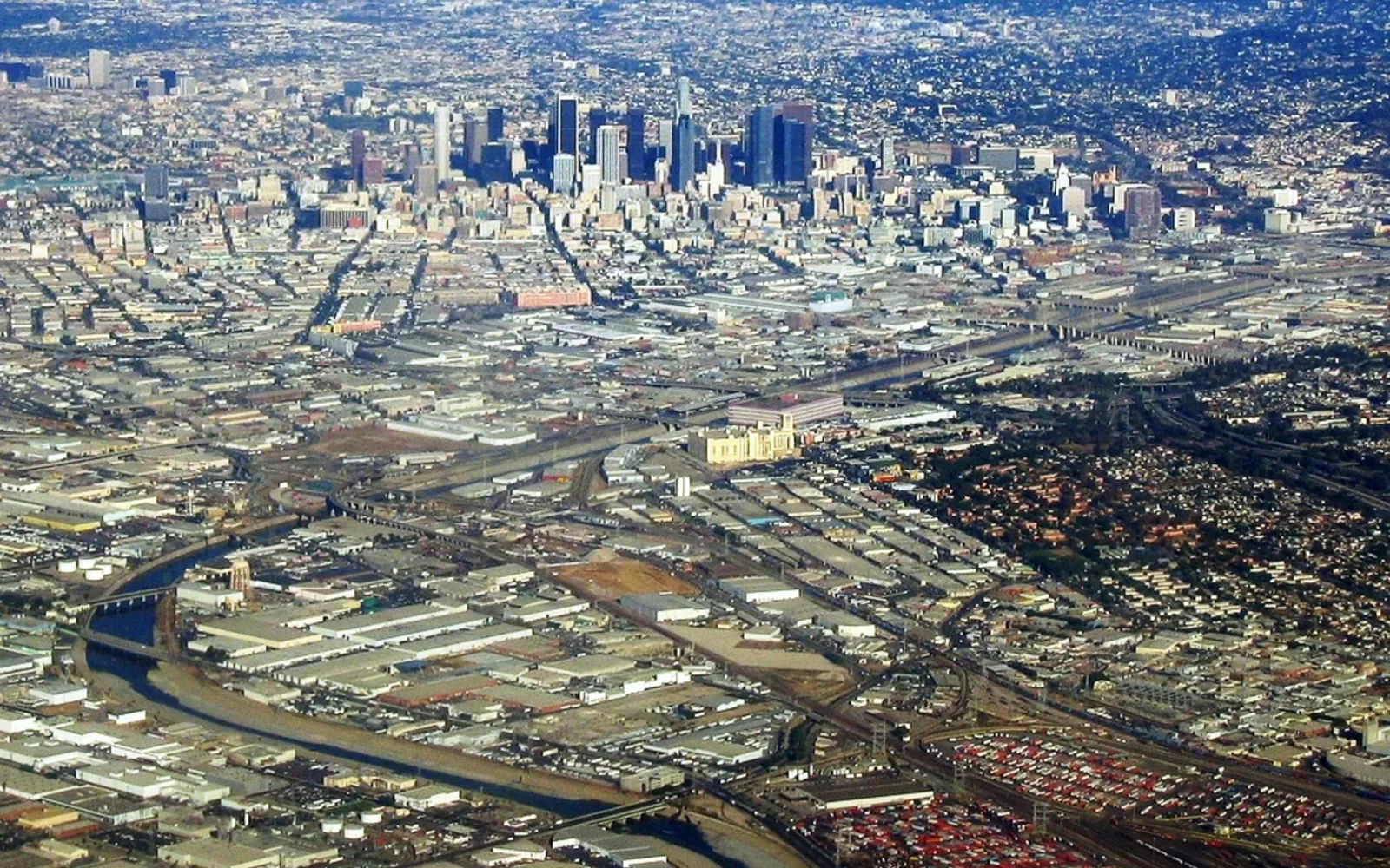 The Los Angeles River flowing through East Los Angeles with downtown skyline in the background
