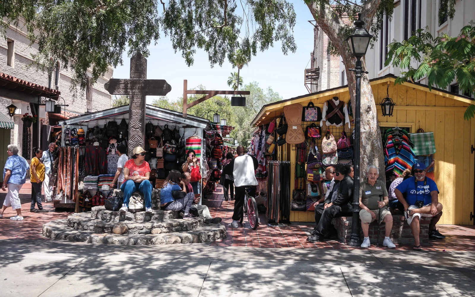Vibrant view of Olvera Street in historic El Pueblo de Los Ángeles, with colorful flags and marketplace buildings